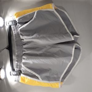 Under Armour, size M gray/yellow lined athletic shorts with pockets